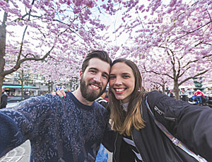 Ett par som tar selfie vid körsbärsträden i Stockholm