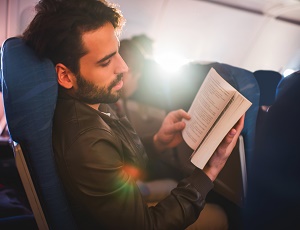 Man läser bok på flyg